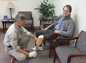 Stuart checking the prosthetic leg of an amputee